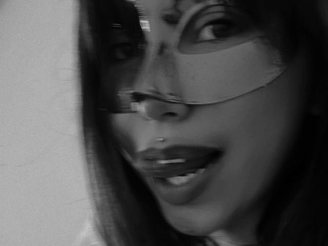 Black and white photo of ElizabethMacy with glasses, showing her nose and smiling mouth with dark lipstick. Her eyes are partially visible, and her hair is on the left.