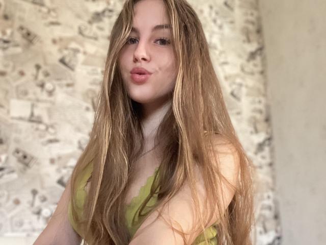 Doris tiene el pelo rubio largo y con aspecto húmedo, labios rosados y finos, una blusa verde de encaje que deja ver sus pequeños senos, y mira a la cámara con una expresión ligeramente seductora..