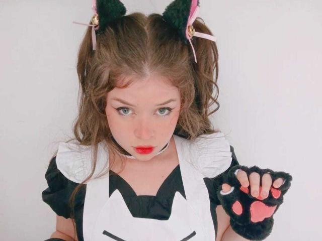 EvaRavissante with cat ears, red lipstick, black puffy sleeves, white apron, black paw gloves, wavy brown hair, and green eyes, looking up with a slightly pouty expression.