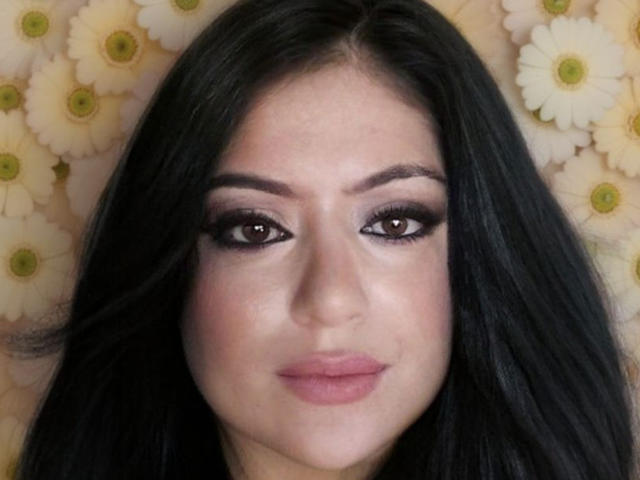 Alondra89 has dark, wavy hair, brown eyes with heavy eyeliner, and pink lipstick. She's looking straight at the camera with a subtle, confident smile.
