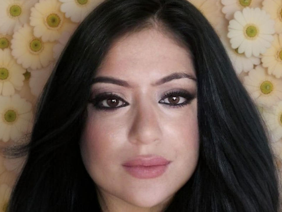 Alondra89 has dark, wavy hair, brown eyes with heavy eyeliner, and pink lipstick. She's looking straight at the camera with a subtle, confident smile.
