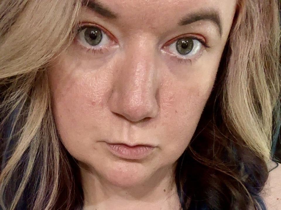 CrystalRivers has a serious face with light green eyes, slightly flushed pink skin, and blonde hair with brown highlights. Her small nose and neutral expression are visible.