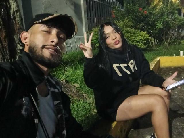 SachaAndFercho with a beard and cap, left, smiling with eyes closed, winking. Fercho, right, with black hair, making a peace sign, in a black TT shirt.