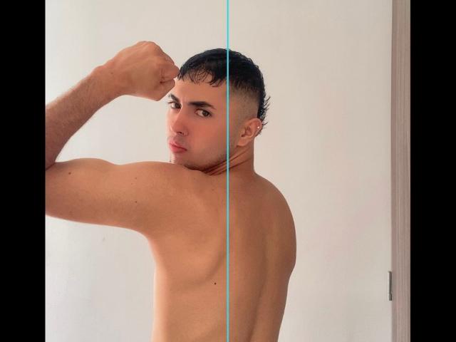 BaironSinclair, shirtless, flexing bicep, short black hair, slight pompadour, light skin, small ear piercing, looking over shoulder, blue glass line, muscular back, subtle facial expression.