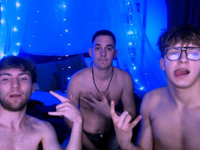 Three shirtless TravisJosephJasons in a blue-lit room, with TravisJosephJason on the left pointing, TravisJosephJason in the middle making a "rock on" gesture, and TravisJosephJason on the right with eyes closed and tongue out.