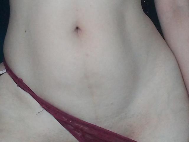 ImFireMoon's pale, flat, bare belly with a small navel, wearing red, slightly lowered, sheer panties that barely cover her pussy.