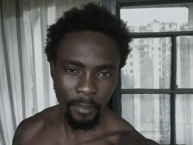 TheBlackStallionn is a shirtless, dark-skinned dude with a curly afro and a goatee, staring into the camera with a serious expression. His chest is visible.