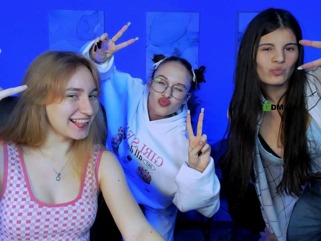 MonaLizzieGinger with blonde hair, small tits, pink checkered tank, MonaLizzieGinger with glasses, pout, white hoodie, MonaLizzieGinger with long brown hair, green collar, making peace signs.