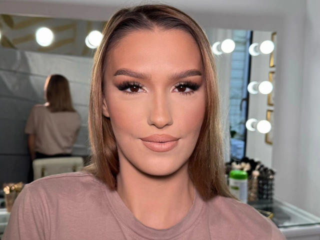 LaraStonne has a sexy face with long, straight blonde hair, full lips, and brown eyes. She's wearing a pink top and has makeup with prominent eyelashes.