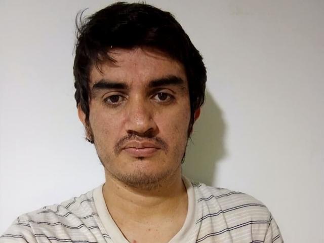 BigestLatin has a medium skin tone, dark messy hair, brown eyes, a small mustache, and is wearing a white and blue striped shirt. His face looks slightly sweaty.
