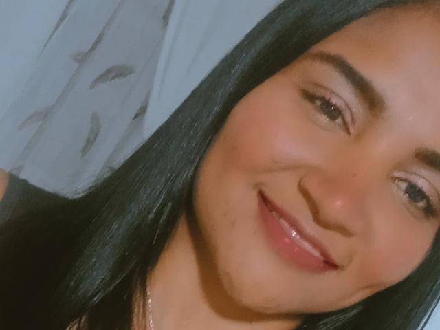 SusanaDiaz has a cute smile with glossy pink lips, black straight hair, and brown eyes, looking slightly to the side with a gentle, confident expression.