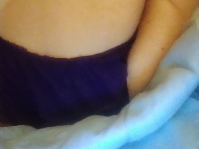 Kimy69's butt in purple lace panties, hand in pocket, light blue blanket, skin is pale, soft texture, slight shadow, subtle curves, casual and relaxed.