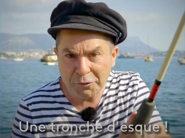 oliviermodeltest, middle-aged dude, black flat cap, striped shirt, fishing rod, serious face, slight tan, small goatee, blue water, mountains in background, sunny day.