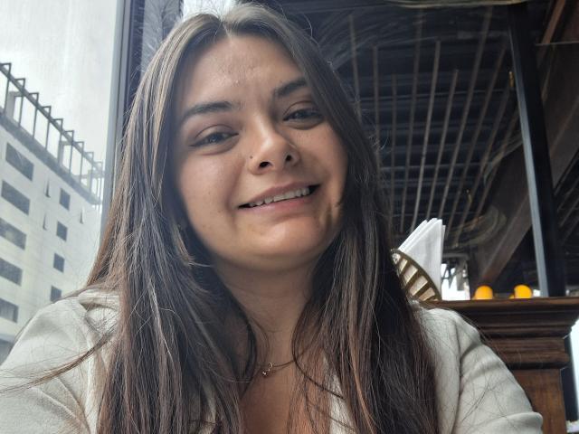 Katherin Latin a de longs cheveux bruns, un sourire charmant et un petit nez. Elle porte un haut blanc, avec un collier en or discret, et on la voit détendue et heureuse sur une photo d'elle-même..