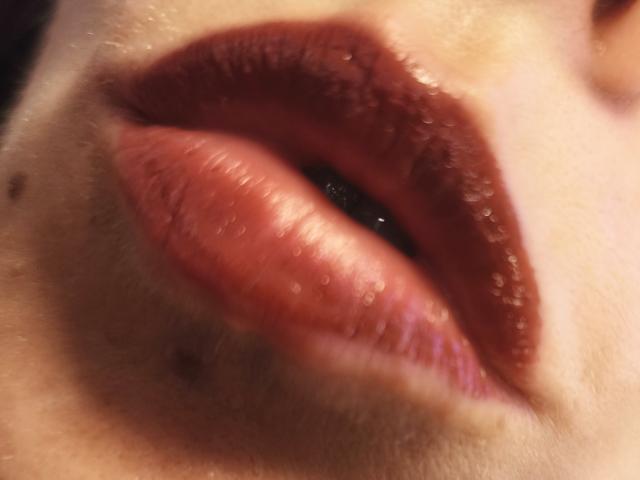 OrianaLaFrancaise's plump, glossy, dark red lips are centered in the image, showing detailed texture and subtle pinkish hues. Her slightly parted upper lip is visible.