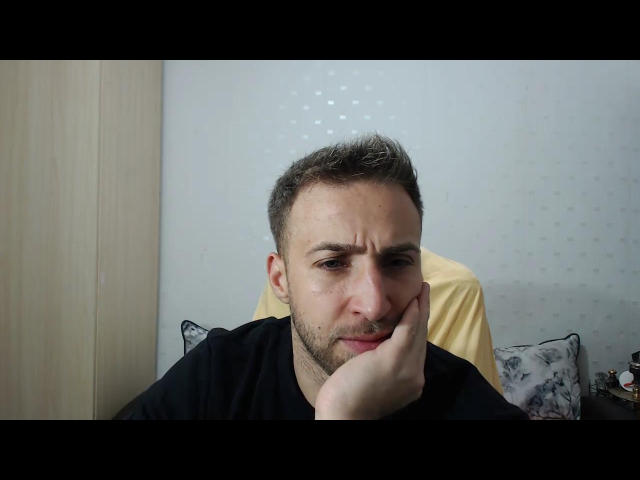 BlondEagle, a slightly dirty-faced dude with short brown hair, is pouting with his hand on his cheek, wearing a black shirt, looking annoyed.