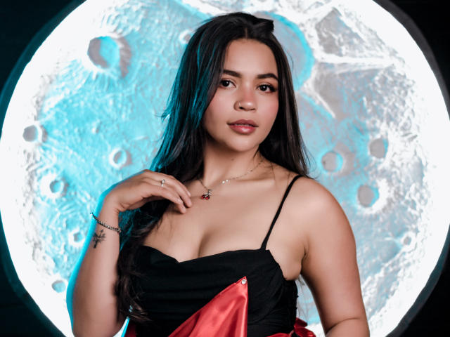 KimDevinne with black and red dress, small tits, Asian, long dark hair, blue highlights, necklace, ring, bracelet, tattoo on right wrist, looking at camera, moon-like background.