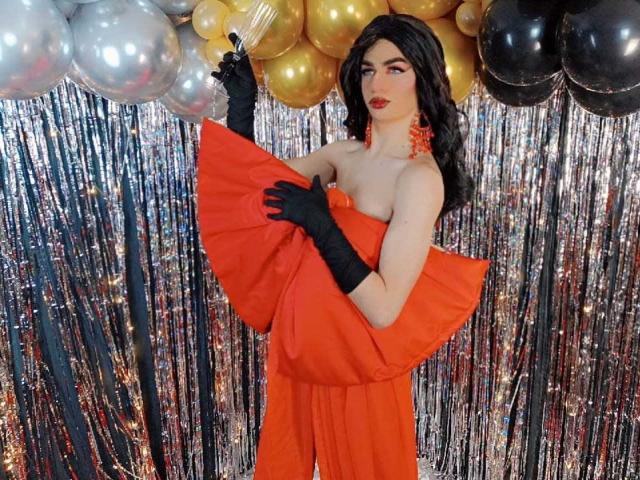 KendallSky with long black hair, red dress, black gloves, holding dress, standing with shiny balloons, and silver streamers. Boobs visible, no ass or pussy shown.