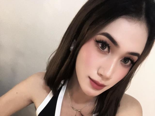 PreciousHorny has brown shoulder-length hair, dark eyebrows, and is wearing a black-and-white halter top. She has a nose ring, eyeliner, and a subtle smile. Her tits are small.