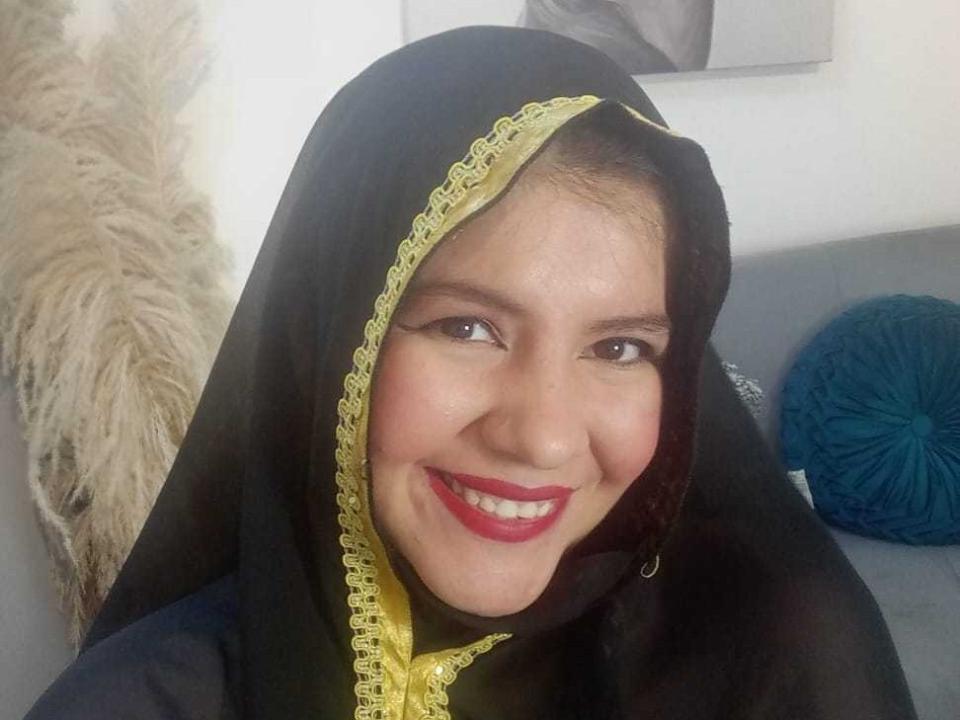 KathlenRousse with a black headscarf and yellow lace, smiling with red lipstick, brown eyes, and fair skin, showing off her cute face and pretty ass in a selfie.
