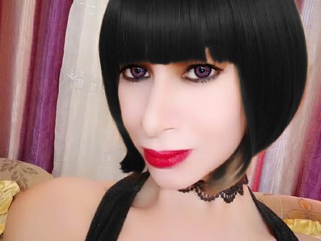 SexyTopHotMistress has black bob, purple eyes, red lipstick, black choker, pale skin, and is wearing a black top. Boobs are visible, but not the focus.