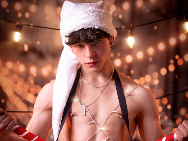 LukeHowlandy with a white furry hat, wearing a cross necklace, Christmas lights on chest, holding candy canes, has a muscular build, short brown hair, and a serious expression.