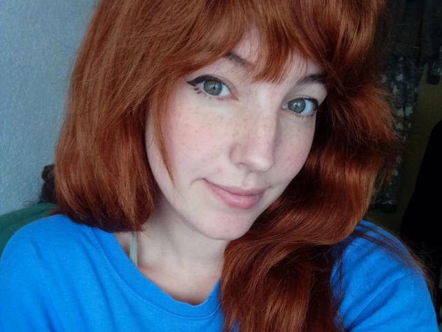 LoveKiitsune-hot with red hair, blue eyes, and freckles, wearing a blue shirt, smiling softly at the camera, showing her cute face and natural beauty.