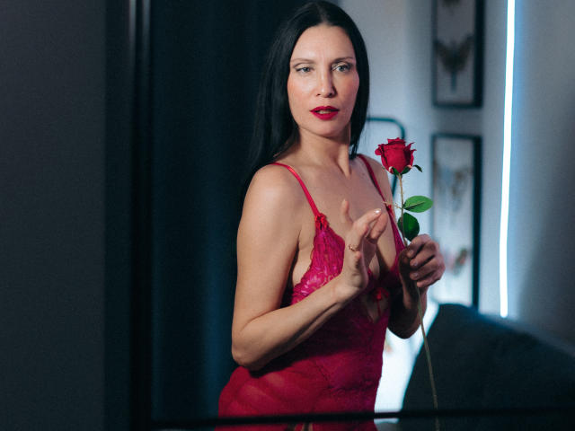 EvanessaJohn with long black hair, red lace lingerie, holding a red rose, standing, looking at camera, slightly smiling, medium tits, fair skin, red lipstick, sexy.