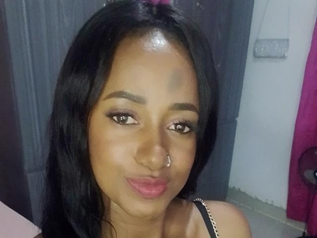 Creten tiene la piel de color marrón oscuro, cabello negro, ojos marrones, un piercing en la nariz y labios rosados. Está haciendo un puchero ligeramente. Lleva una correa negra con una cadena..