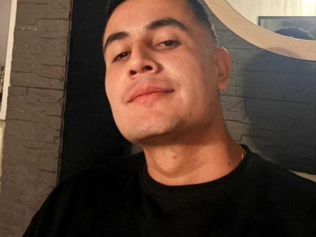 ErickGarciax has a slight, confident smile with short dark hair, light skin, and small, stubbly goatee, wearing a black shirt, looking at the camera.