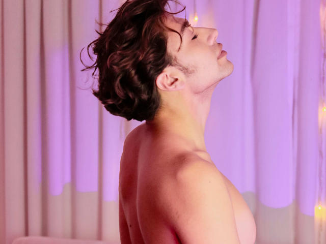 TonyDan, com cabelo castanho encaracolado, olhos fechados, cabeça inclinada para trás, sem camisa, mostrando ombros e peito nus, iluminação suave em tons de rosa e roxo, pele lisa, leve rubor rosado nas bochechas..