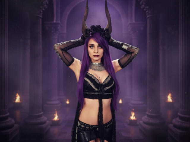 Alexandrapsique with long purple hair, black horns, and a gothic outfit, showing her tits in a lace bra and black gloves, standing in a dark, fiery room.