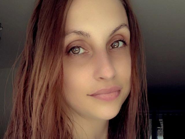 Joie-20-hot has brown eyes, light skin, and straight brown hair, with a subtle smile and pink lips, looking directly at the camera. She's got a cute, attractive face.