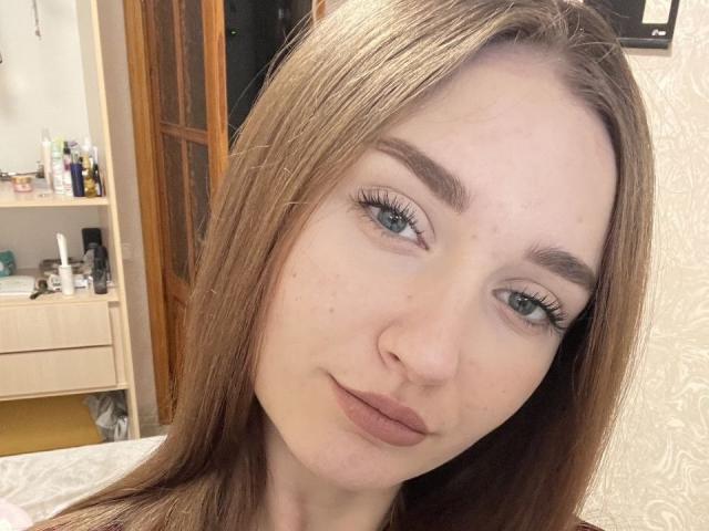 Celestiya tiene el cabello castaño claro, ojos verdes y una nariz pequeña con una ligera sonrisa. Está mostrando sus largas pestañas y sus pecas en un selfie..