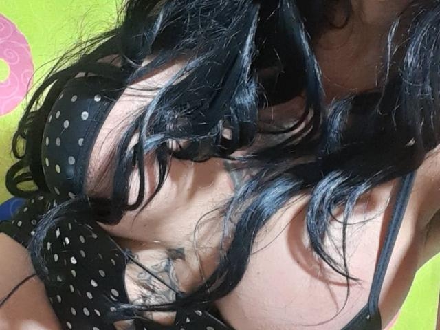 De zwarte beha met stippen van Roberta Horney bedekt nauwelijks haar grote, ronde borsten, terwijl haar lange, golvende zwarte haar over haar borst valt. Tattoos zijn zichtbaar op haar rechterkant, onder in haar borst..