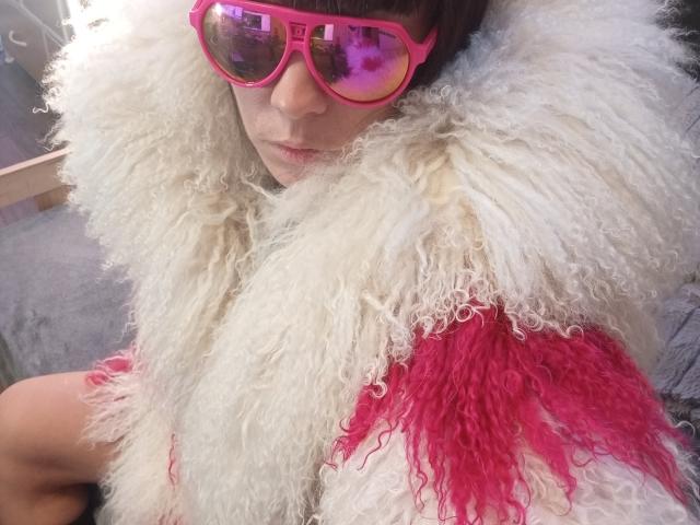 OrianaLaFrancaise with curly white and pink fuzzy scarf, pink sunglasses reflecting purple, wearing nothing visible below the scarf, looking down, pale skin, brown bangs.