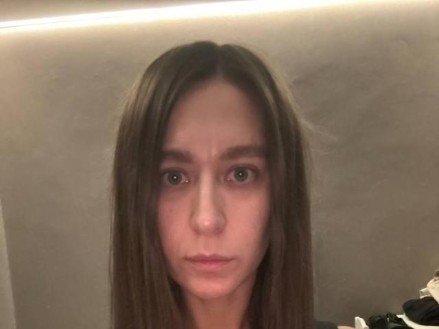 Sanezhka has straight brown hair, brown eyes, and a pouty face. She's looking directly at the camera with a neutral expression. Her nose is slightly upturned.