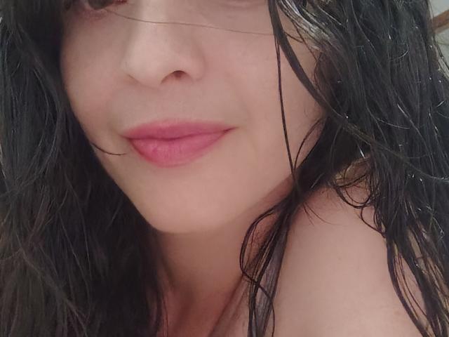 LatinaCulChaud's face, wet black hair, pink lips, slight smile, bare shoulder, pale skin, close-up. Boobs not visible. Ass not visible. Tits not visible. Pussy not visible.