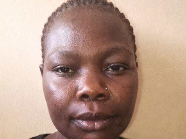 CindyBae has dark brown skin, small nose piercing, and short braided hair. She's looking straight at the camera with a slight smile. Her lips are shiny.