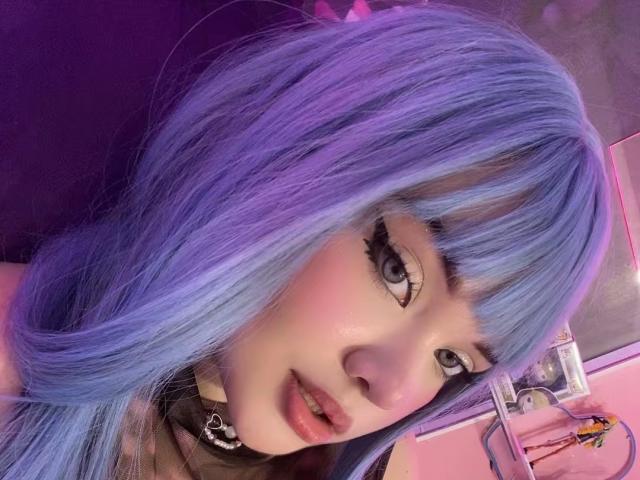 AlayaWillow has purple-blue hair, big eyelashes, and a cute face with pink cheeks, wearing a black choker with a crescent moon. Her eyes are looking at the camera.