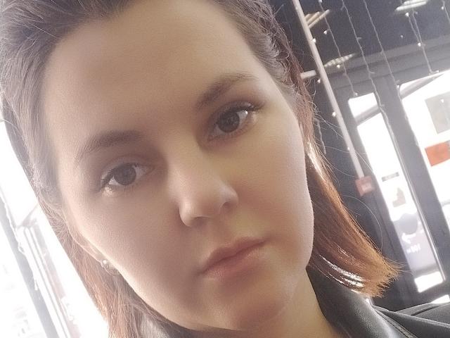MabelMyriam's face, featuring soft brown eyes, light skin, and brown hair in a side part, wearing a black leather jacket, with a subtle, neutral expression.