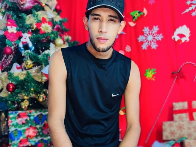 UnitedSou, un joven atractivo con una camiseta negra sin mangas de Nike y una gorra, tiene un ligero bigote y mira a la cámara con una expresión relajada..