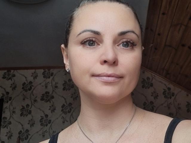 AlinaBurleck has a cute face with light skin, green eyes, and a slight smile. She's wearing a black top, has a thin necklace, and her hair is pulled back.