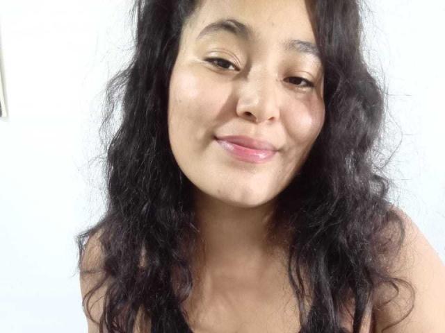 SexyLovve69 has wavy black hair, a light brown skin tone, and a slight smile with pink lips, showing a relaxed and confident expression in the photo.