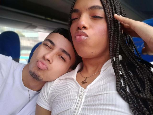 ThePerfectCouple has a cute, brown-skinned woman with long braids and pouty lips, next to a brown-skinned man with a beard, both making kissing faces in a bus.