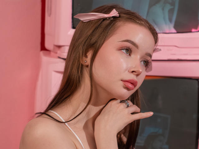 ViolettaFane with pink ribbon in brown hair, looking to the side, slightly glossy skin, pink lipstick, small nose, white strap top, hand near chin, pink window frame.