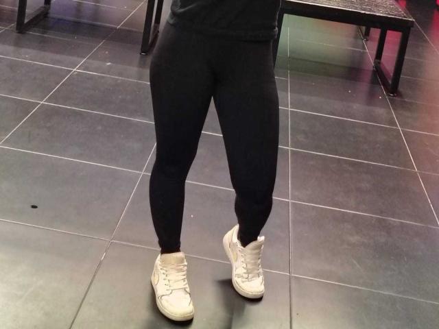 AmyStreetwise69's black leggings and white sneakers on dark tile floor. Her lower body is visible, showing her butt and legs, but no upper body.