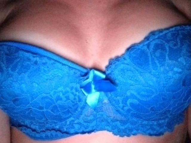 JuliannaQ's blue lace bra with a small bow in the center, covering her tits. The bra has a floral pattern and bright blue ribbon accents.