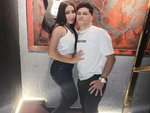 ViolettAndRyuk with long black hair, tits in a white crop top, and black pants, standing next to Ryuk with short black hair, white tee, and black pants.