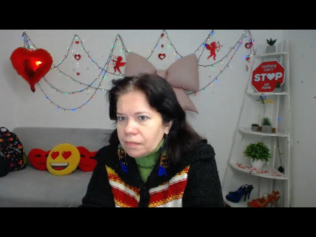 ScarlettWotte has medium brown hair, green turtleneck, black and red striped sweater, and a large pink bow. She's wearing blue earrings, looking slightly annoyed, with a heart balloon.